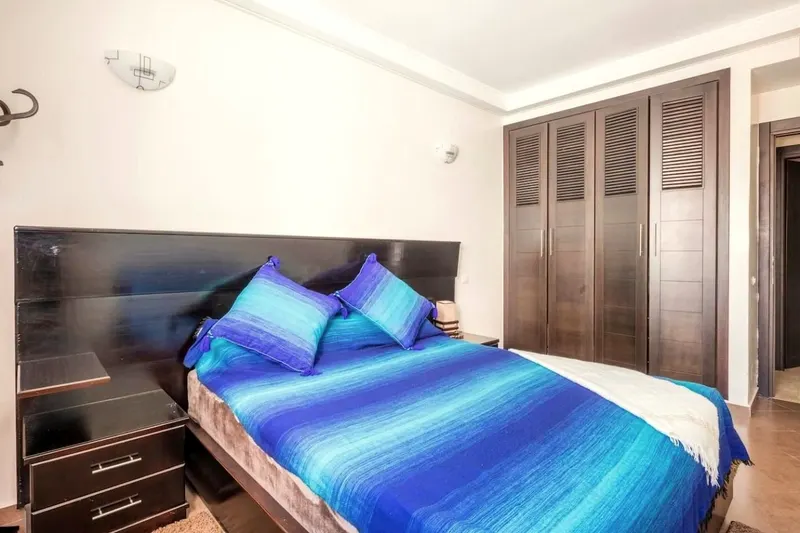 Bedroom: large double bed, dark headboard and a full-height wardrobe