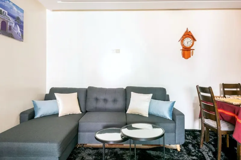 Salon 2: a grey chaise sofa with pale-blue cushions and two round nesting tables
